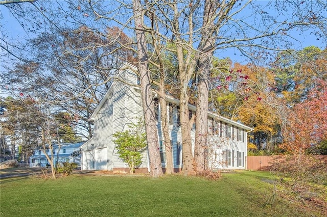 view of home's exterior with a garage, a yard, and fence