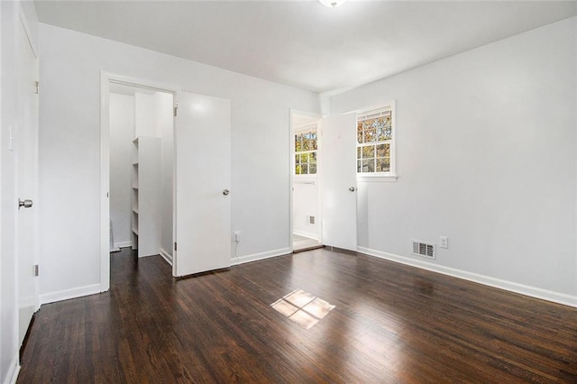 unfurnished room with dark wood-type flooring