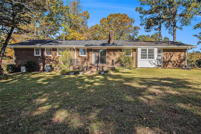 back of property with central air condition unit and a yard