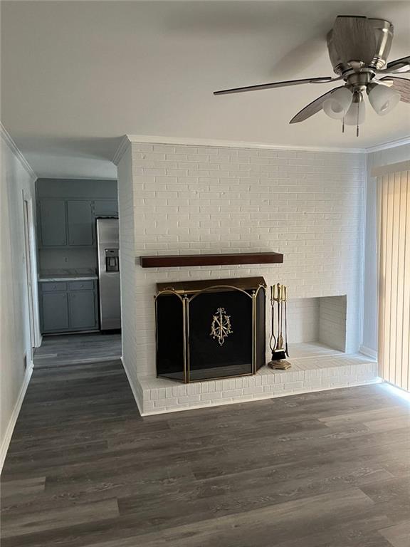 details featuring ceiling fan, a brick fireplace, stainless steel fridge with ice dispenser, crown molding, and wood-type flooring