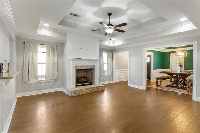 living room with dark hardwood / wood-style flooring, crown molding, and a raised ceiling