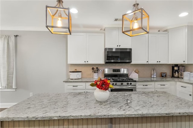 kitchen featuring pendant lighting, stainless steel appliances, and white cabinets