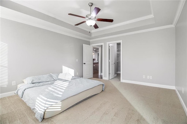 bedroom with crown molding, a walk in closet, a tray ceiling, carpet flooring, and ceiling fan