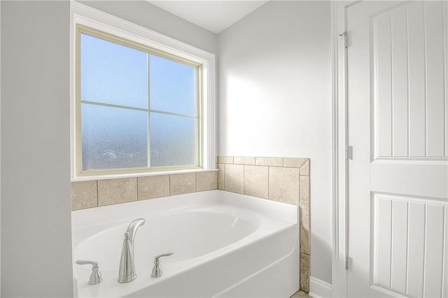 bathroom featuring plenty of natural light and a tub