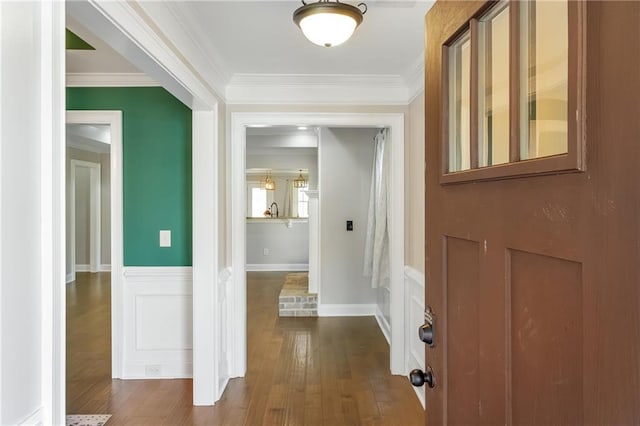 corridor with crown molding, sink, and hardwood / wood-style flooring