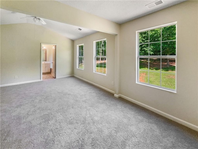 spare room with ceiling fan, carpet floors, and vaulted ceiling