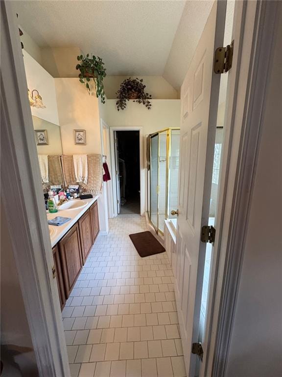 2246 Carrington Dr, Ellenwood, GA 30294 - full bath featuring lofted ceiling, tile patterned floors, double vanity, a sink, and a stall shower