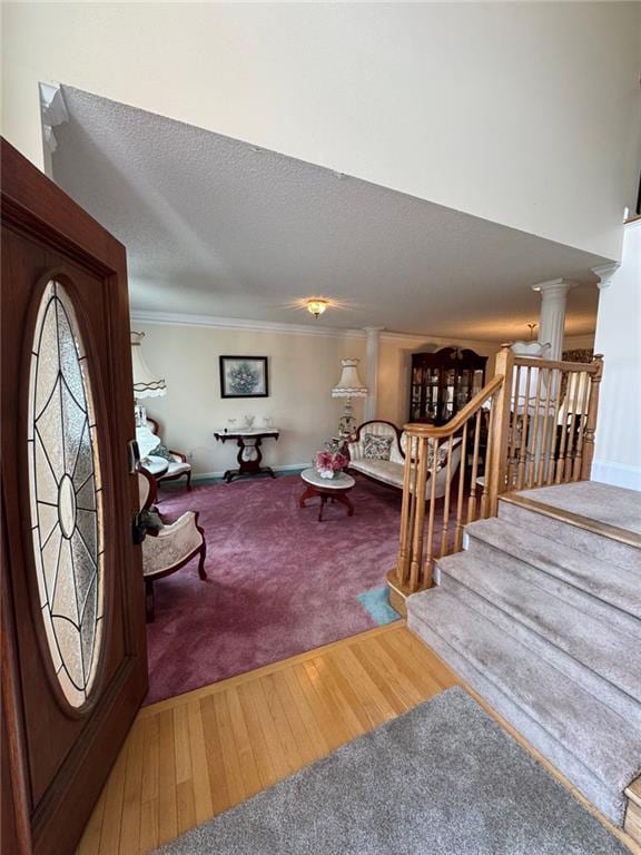 2246 Carrington Dr, Ellenwood, GA 30294 - carpeted living area featuring a textured ceiling, baseboards, wood finished floors, stairway, and crown molding