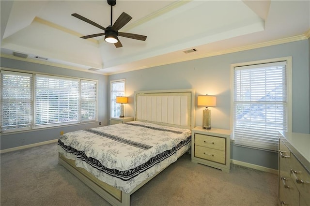 bedroom featuring a tray ceiling, multiple windows, ceiling fan, and carpet