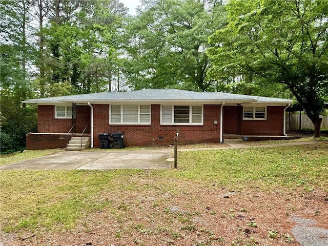 ranch-style house featuring brick siding, fence, and a front yard