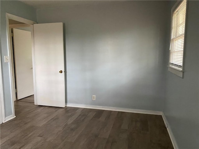 spare room featuring wood finished floors and baseboards