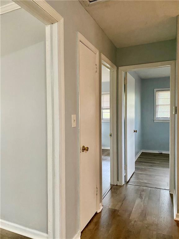 hallway with wood finished floors and baseboards