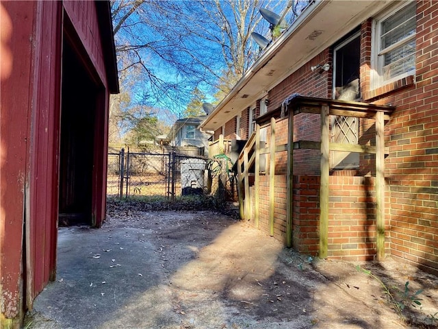 view of side of property with fence and brick siding