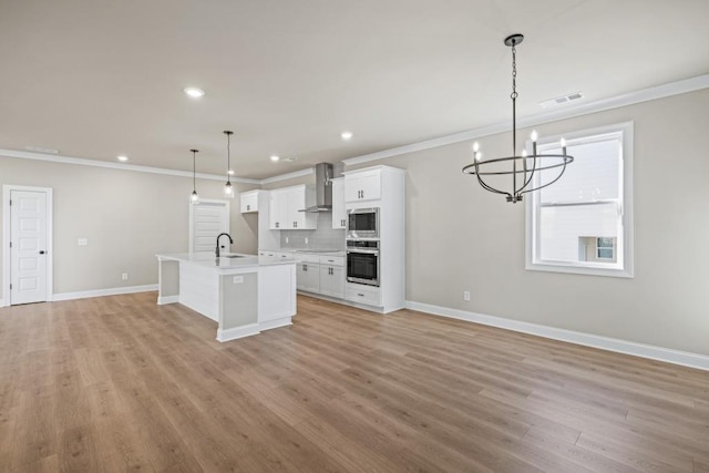 kitchen featuring a sink, appliances with stainless steel finishes, open floor plan, and crown molding