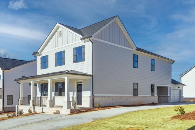 modern farmhouse with brick siding, board and batten siding, concrete driveway, covered porch, and a garage