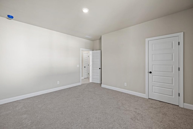 empty room featuring recessed lighting, carpet, and baseboards