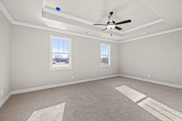 carpeted empty room with a tray ceiling, baseboards, and visible vents