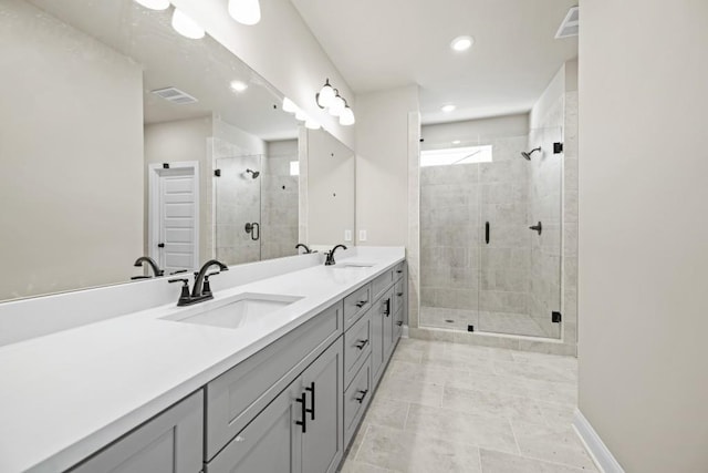 full bathroom with double vanity, visible vents, a stall shower, and a sink