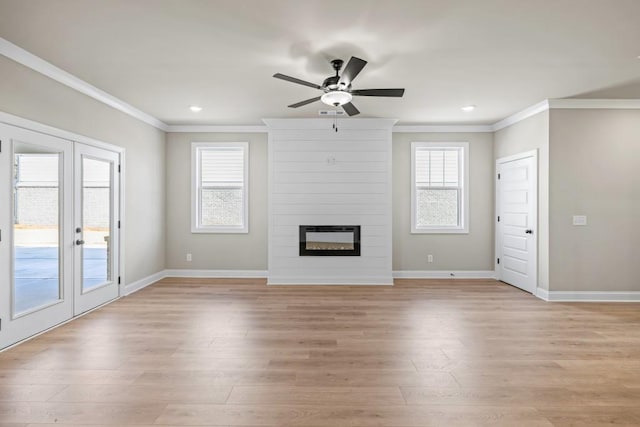 unfurnished living room featuring light wood finished floors, a fireplace, baseboards, and ornamental molding