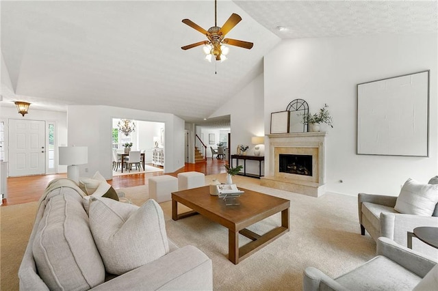 8770 Amberfield Dr, Gainesville, GA 30506 - living area featuring a ceiling fan, a fireplace, light carpet, high vaulted ceiling, and a chandelier