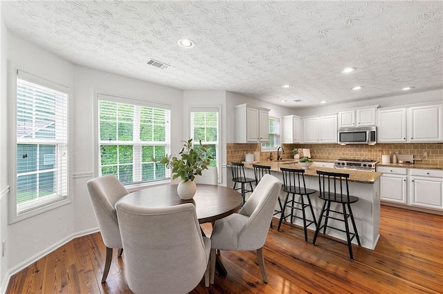 8770 Amberfield Dr, Gainesville, GA 30506 - dining space featuring healthy amount of natural light, a textured ceiling, hardwood / wood-style floors, baseboards, and recessed lighting
