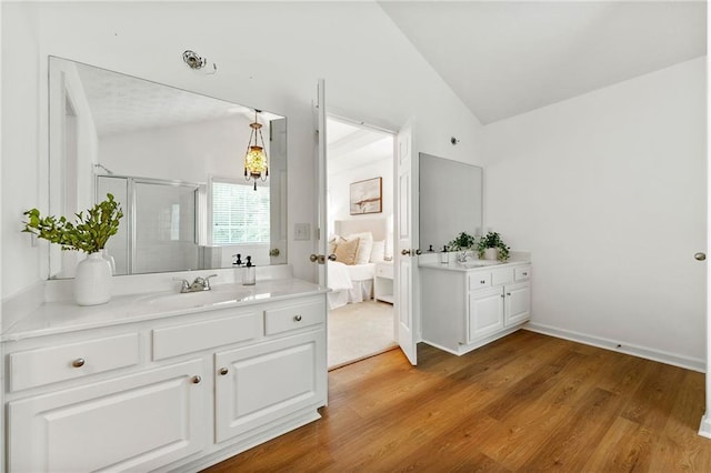 8770 Amberfield Dr, Gainesville, GA 30506 - ensuite bathroom featuring lofted ceiling, two vanities, a shower stall, and wood finished floors