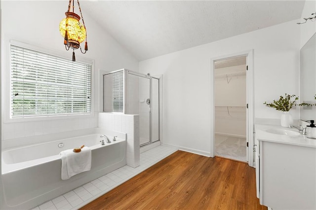 8770 Amberfield Dr, Gainesville, GA 30506 - bathroom featuring a shower stall, a bath, vanity, wood finished floors, and lofted ceiling