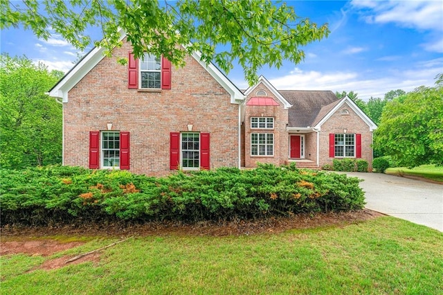 8770 Amberfield Dr, Gainesville, GA 30506 - traditional-style house featuring brick siding, a front lawn, and driveway