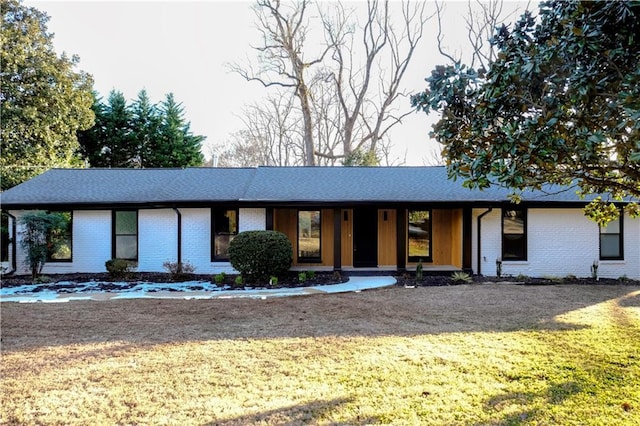 view of front facade featuring brick siding and a front lawn