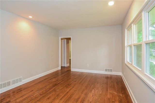 empty room featuring dark hardwood / wood-style flooring and a healthy amount of sunlight