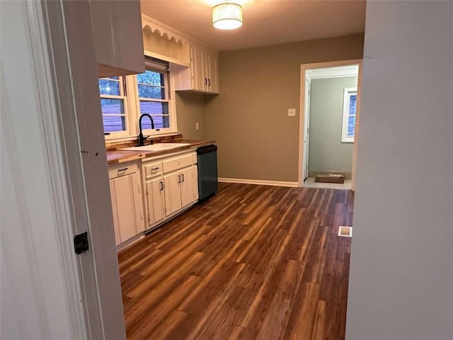 kitchen featuring sink, white cabinets, dark hardwood / wood-style floors, and black dishwasher