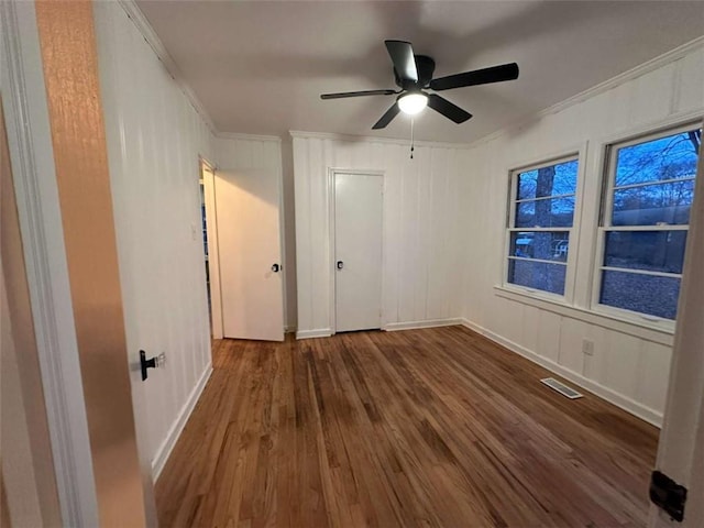 unfurnished bedroom with ceiling fan, hardwood / wood-style floors, and crown molding