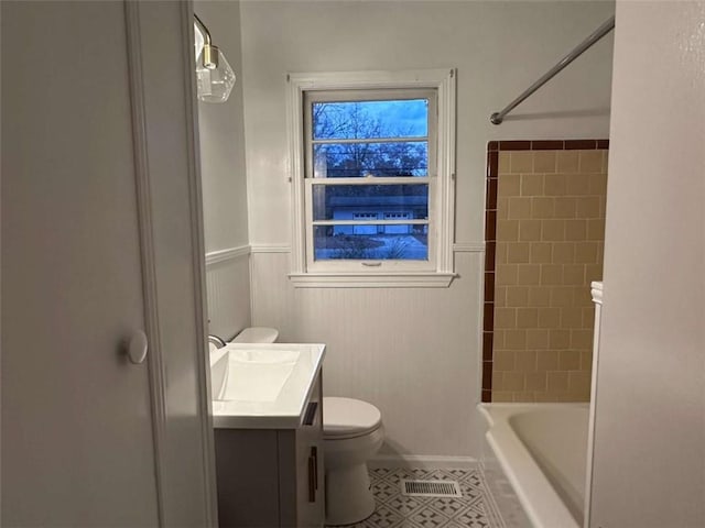 full bathroom with tile patterned flooring, vanity, tiled shower / bath combo, and toilet