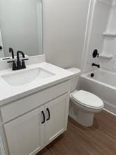 full bathroom featuring toilet, tub / shower combination, wood finished floors, and vanity