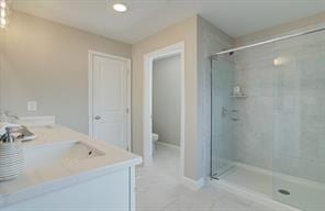 bathroom featuring a stall shower, tile patterned flooring, vanity, and toilet