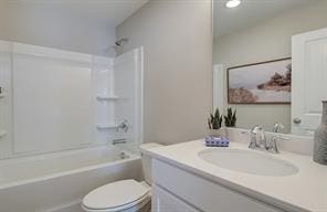 bathroom featuring vanity, toilet, and bathing tub / shower combination