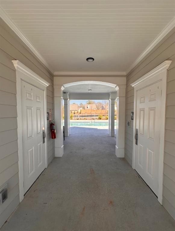 hallway featuring arched walkways and ornamental molding