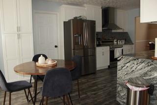 5022 Cliff Top Dr, Loganville, GA 30052 - kitchen with extractor fan, dark wood-style flooring, white cabinets, and appliances with stainless steel finishes