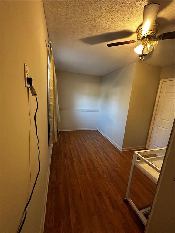 5022 Cliff Top Dr, Loganville, GA 30052 - spare room with a textured ceiling, baseboards, a ceiling fan, and wood finished floors