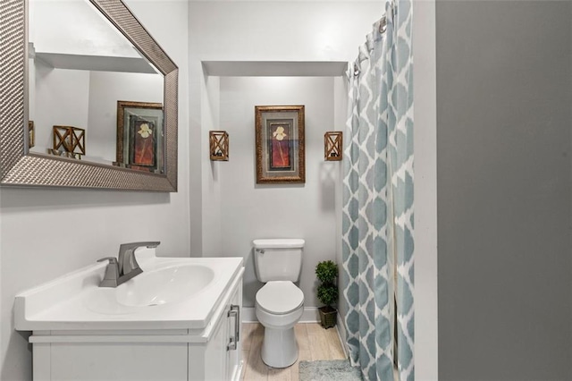 bathroom featuring vanity, toilet, and hardwood / wood-style flooring