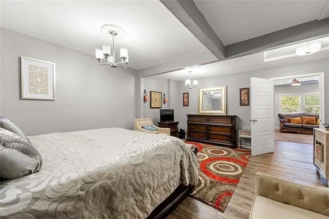 bedroom with beamed ceiling, a chandelier, and hardwood / wood-style flooring