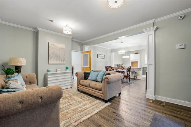 living room featuring crown molding, ornate columns, and wood-type flooring