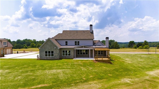 back of property with a garage and a yard