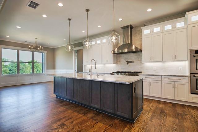 kitchen featuring wall chimney exhaust hood, dark hardwood / wood-style flooring, white cabinets, and an island with sink