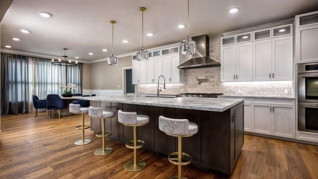 kitchen with sink, white cabinets, dark hardwood / wood-style flooring, and wall chimney exhaust hood