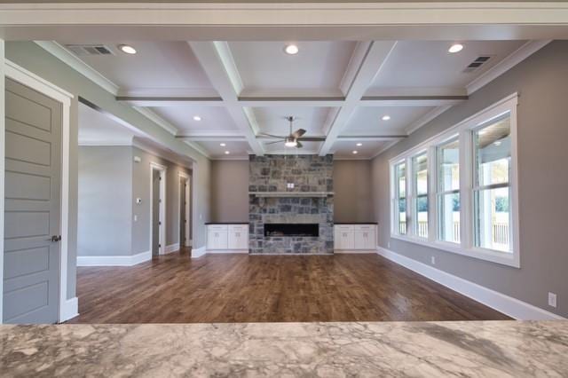 unfurnished living room with ceiling fan, a fireplace, hardwood / wood-style floors, and coffered ceiling