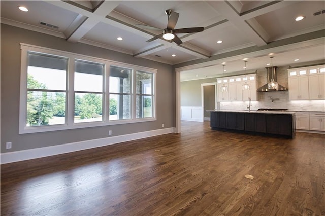 unfurnished living room with ceiling fan, dark hardwood / wood-style flooring, beamed ceiling, and coffered ceiling