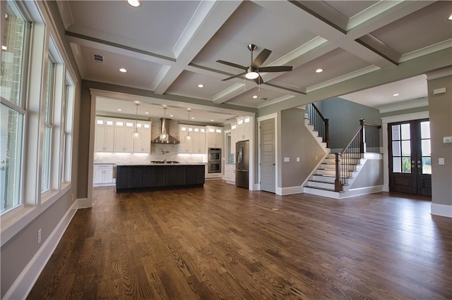 unfurnished living room with ornamental molding, coffered ceiling, beamed ceiling, dark hardwood / wood-style flooring, and ceiling fan