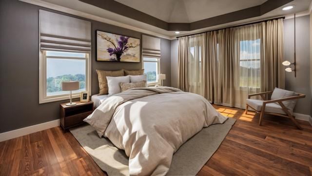 bedroom with multiple windows, a tray ceiling, and hardwood / wood-style floors