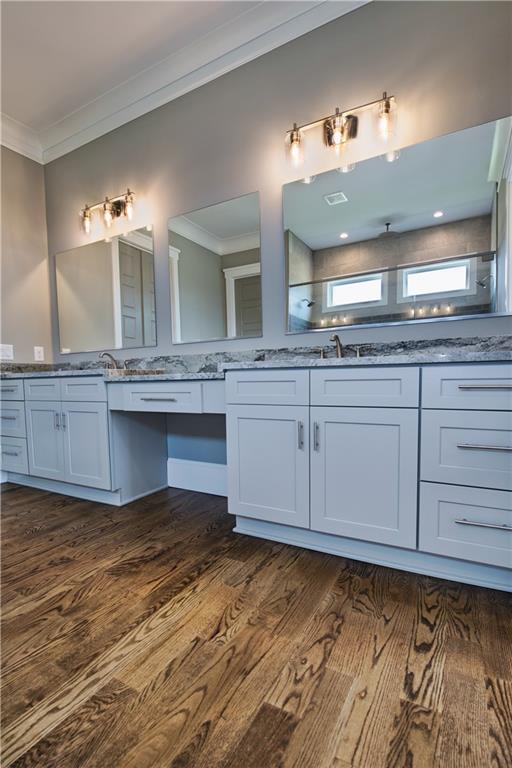 bathroom featuring ornamental molding, dual vanity, and hardwood / wood-style flooring